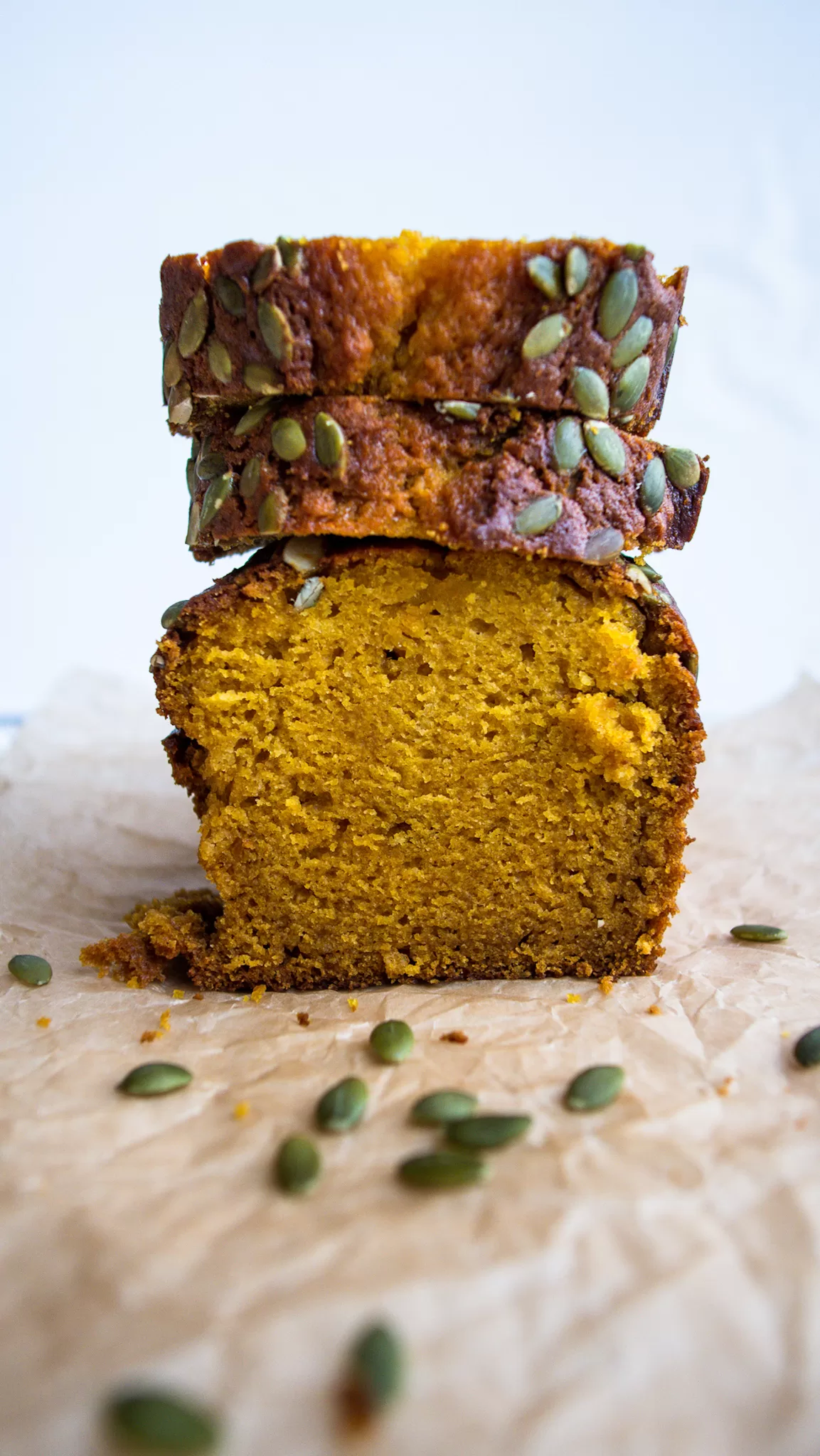 pumpkin bread slices stacked on the loaf