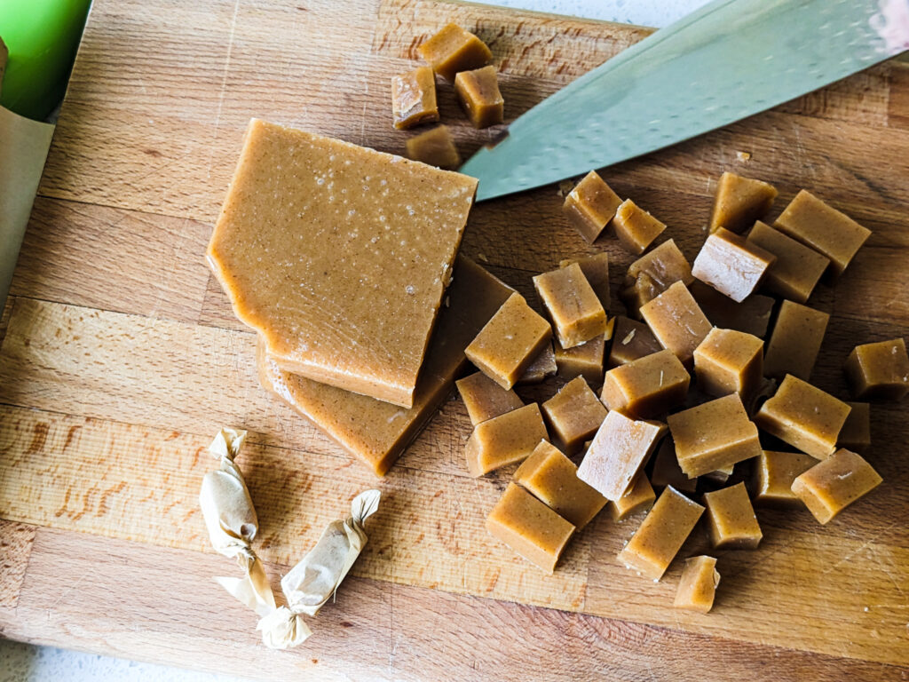 a block and cut caramel pieces on a cutting board