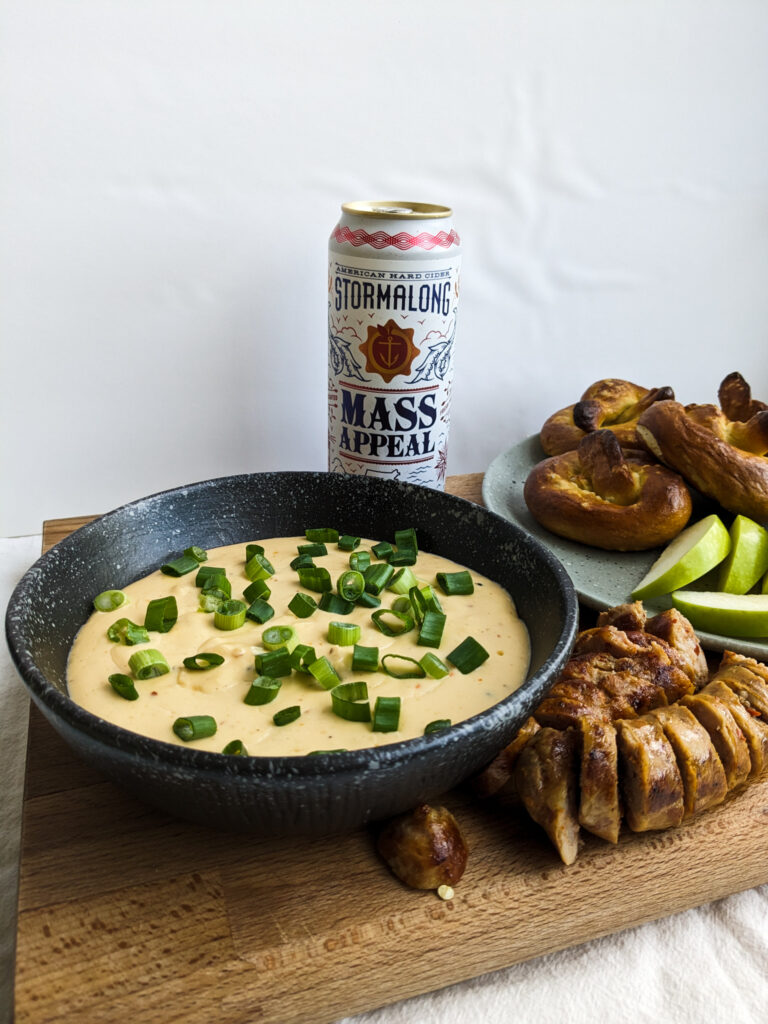 apple cider cheese dip with sausage, pretzels, and green apples