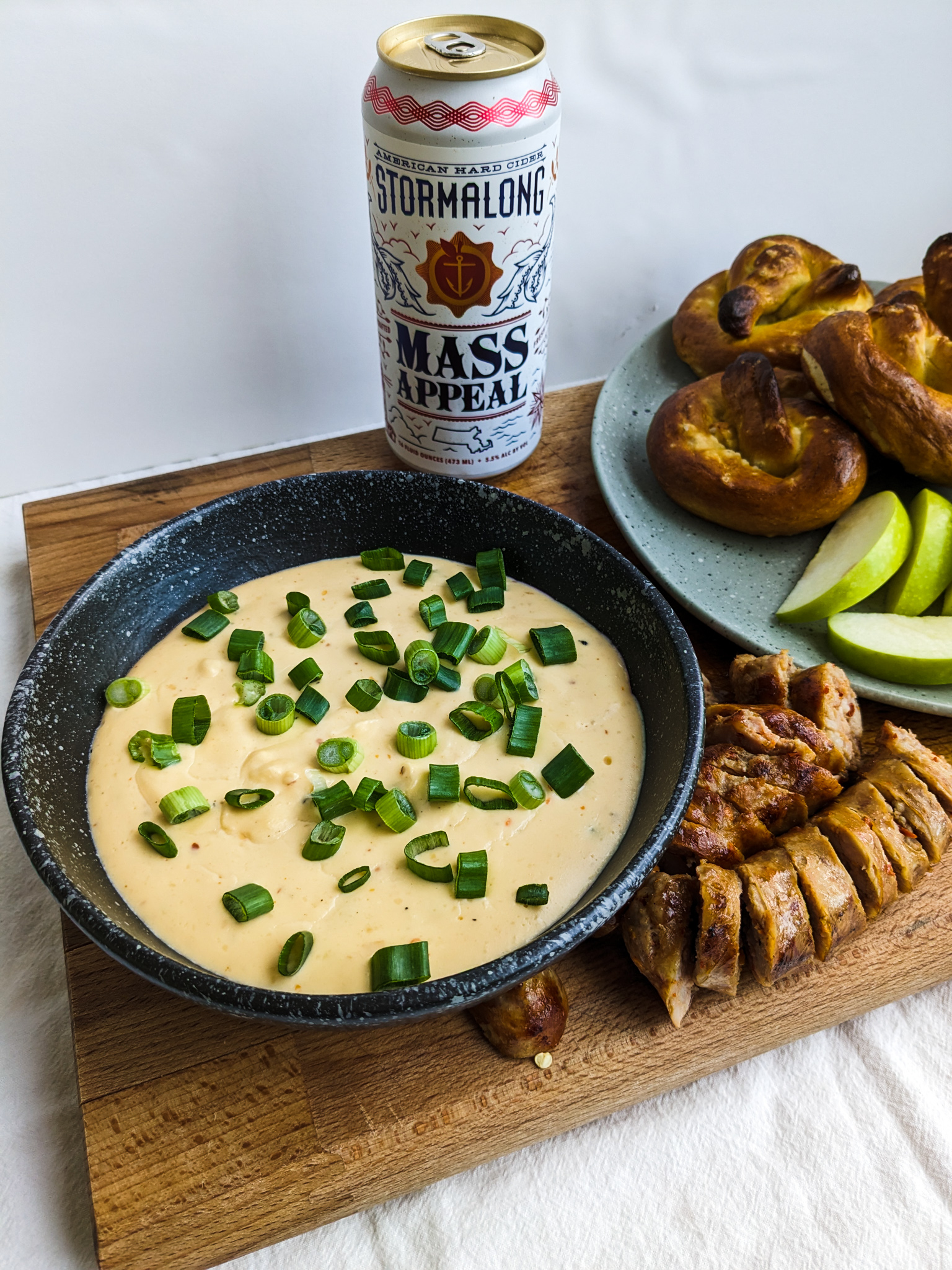 apple cider cheese dip with sausage, pretzels, and green apples
