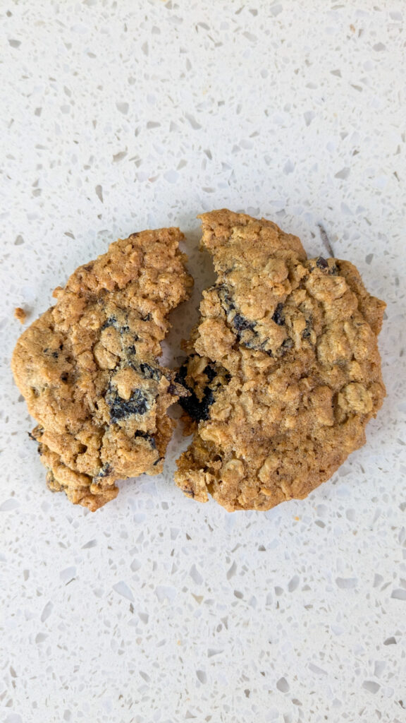 cherry oatmeal cookie split with a white marble background